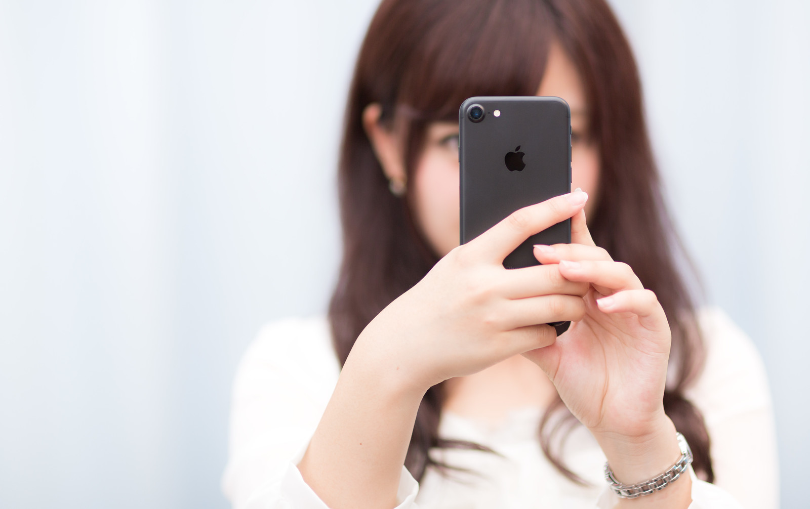 マットブラックカラーのスマートフォンを操作する女性の画像